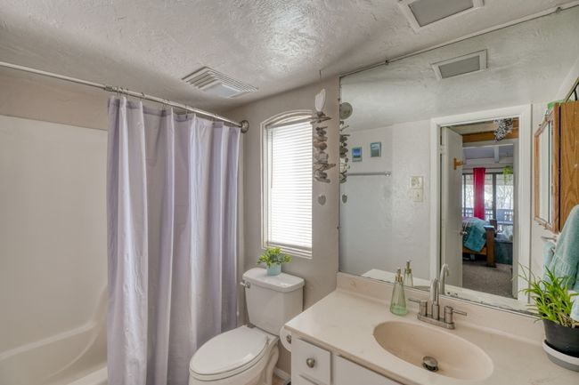 Bathroom with vanity, visible vents, a textured ceiling, curtained shower, and toilet upper unit | Image 24