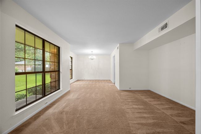 Carpeted spare room featuring a chandelier, healthy amount of natural light, and baseboards | Image 6