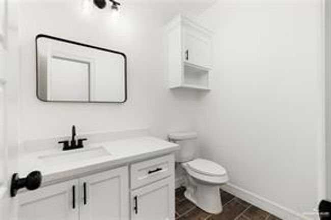 Bathroom with baseboards, vanity, and toilet | Image 13