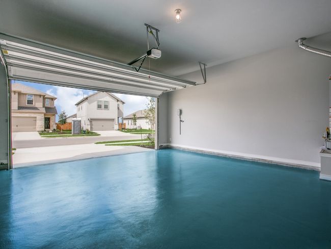 Garage featuring a garage door opener and baseboards | Image 19
