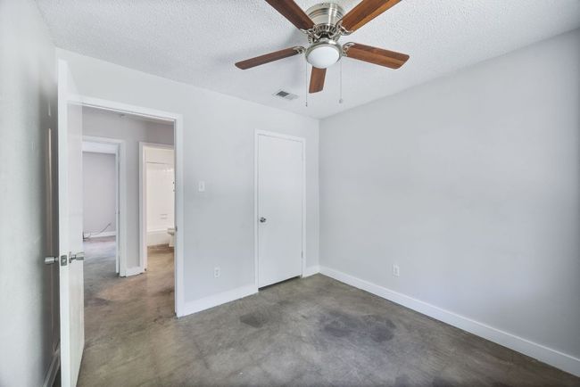 Unfurnished bedroom with a textured ceiling, a closet, ceiling fan, and concrete floors | Image 16