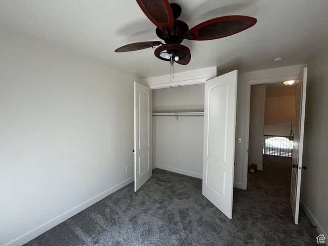 Unfurnished bedroom featuring dark carpet, a closet, and ceiling fan | Image 10