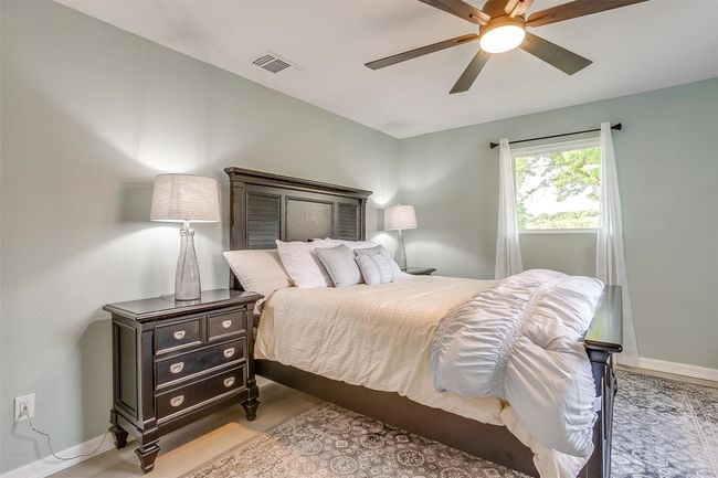 Bedroom featuring baseboards, wood finished floors, visible vents, and ceiling fan | Image 14