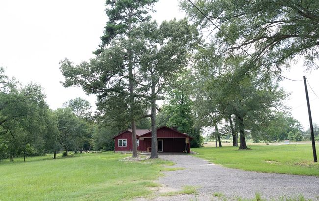 View of grassy yard featuring driveway, an outbuilding, and a pole building | Image 38