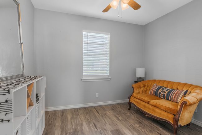 Living area with a ceiling fan, wood finished floors, and baseboards | Image 16
