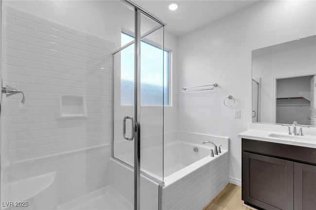 Bathroom featuring a shower stall, a garden tub, vanity, and wood finished floors | Image 27