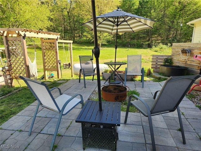 View of patio / terrace featuring an outdoor fire pit, a pergola, and a forest view | Image 29