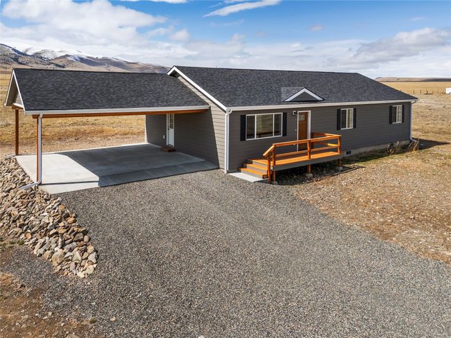 View of front of house featuring an attached carport, a shingled roof, a deck with mountain view, and driveway | Image 10