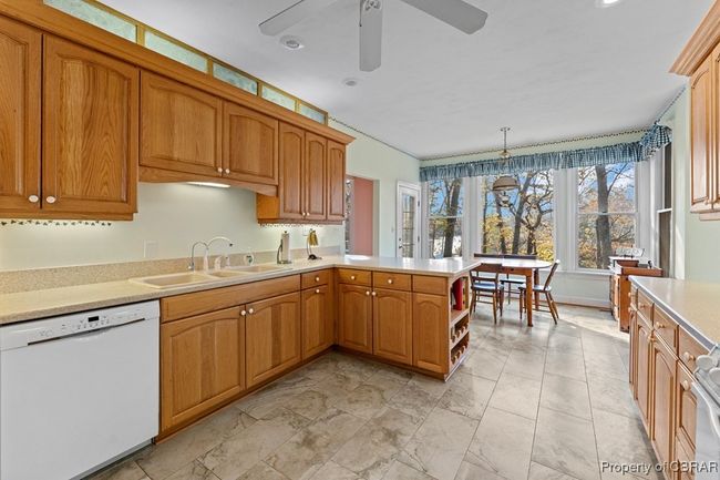 Kitchen featuring dishwasher, a ceiling fan, light countertops, a peninsula, and light marble finish floors | Image 21