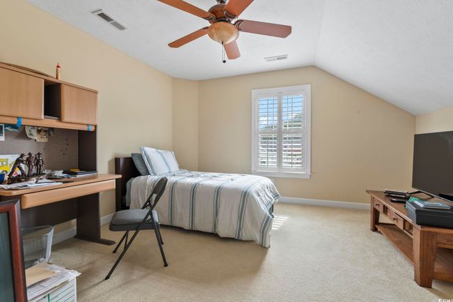 Bedroom featuring lofted ceiling, visible vents, a ceiling fan, and light colored carpet | Image 19