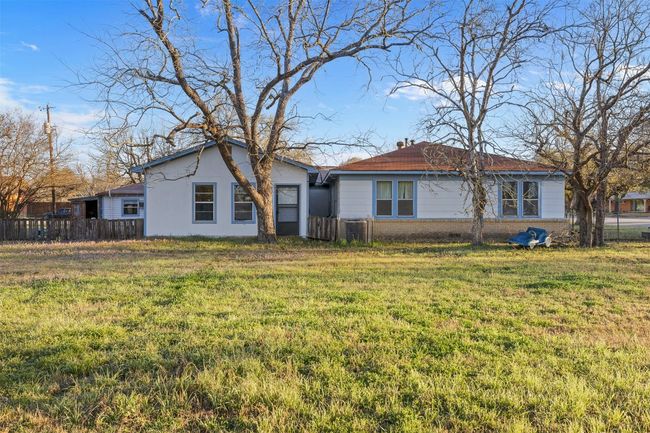 Back of house with a yard, fence, brick siding, and central AC | Image 7