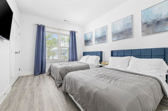 Bedroom featuring baseboards, wood finished floors, and visible vents | Image 19