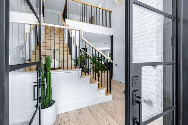 Entryway featuring wood finished floors and stairway, beautiful glass double doors | Image 4