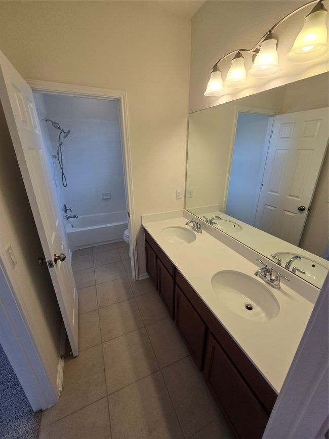Bathroom featuring tile patterned flooring, double vanity, and shower / bathtub combination | Image 25