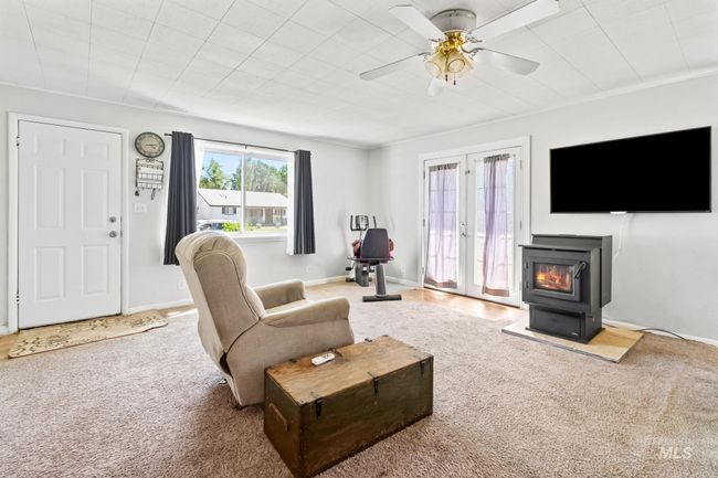 Carpeted living room with a wood stove and a ceiling fan | Image 8