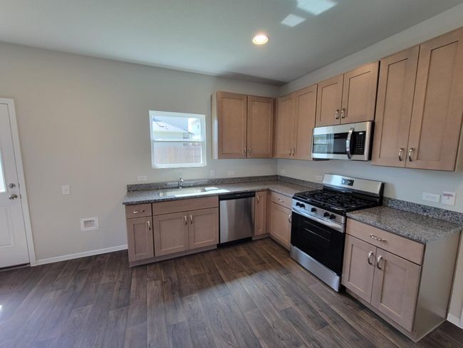 Kitchen with stainless steel appliances, dark wood-style flooring, recessed lighting, and light brown cabinets | Image 9