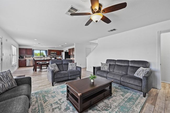 Living area with a ceiling fan, light wood-style floors, recessed lighting, and baseboards | Image 11