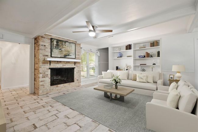 Spacious family room complete with a beautiful fire place, classy built in shelving, tile floors, fresh paint, ceiling fan. | Image 5