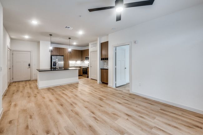 Kitchen featuring dark countertops, visible vents, backsplash, light wood-type flooring, and appliances with stainless steel finishes | Image 21