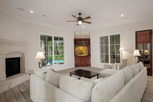 This family room has a fireplace and door leading to the screened in patio | Image 15