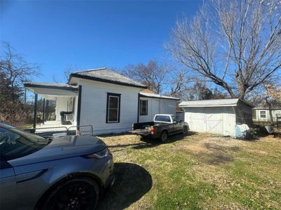 View of property exterior featuring a lawn and a shed | Image 1