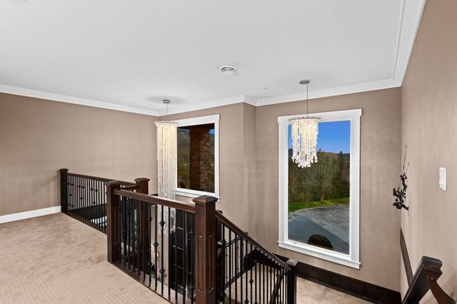 Stairs featuring baseboards, a notable chandelier, crown molding, and carpet flooring | Image 18