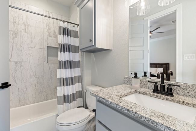 Full bathroom featuring vanity, toilet, visible vents, ceiling fan, and shower / bath combination with curtain | Image 23
