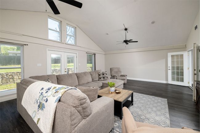 Living area featuring french doors, ceiling fan, visible vents, and dark wood-style floors | Image 23