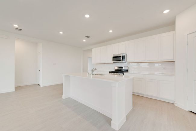 Kitchen with appliances with stainless steel finishes, a sink, light wood-type flooring, tasteful backsplash, and recessed lighting | Image 9