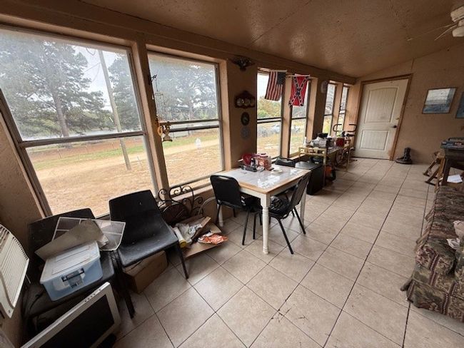 Sunroom featuring lofted ceiling, ceiling fan, and plenty of natural light | Image 17
