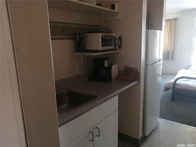 Kitchen featuring freestanding refrigerator, white cabinets, and open shelves | Image 38