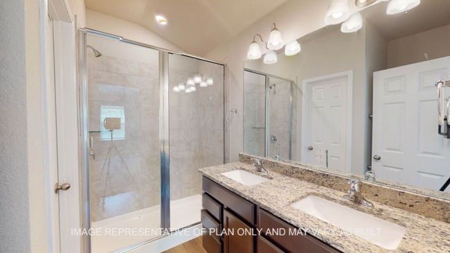 Bathroom featuring a stall shower, double vanity, and lofted ceiling | Image 17