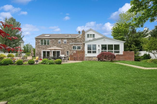 Back of house with a chimney, stone siding, and a patio area | Image 27