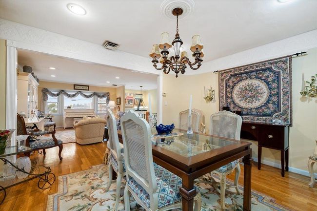 Dining space with an inviting chandelier, light wood-style flooring, baseboards, and visible vents | Image 8
