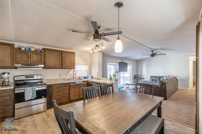 Dining room with light wood-style flooring, rail lighting, and a ceiling fan | Image 21
