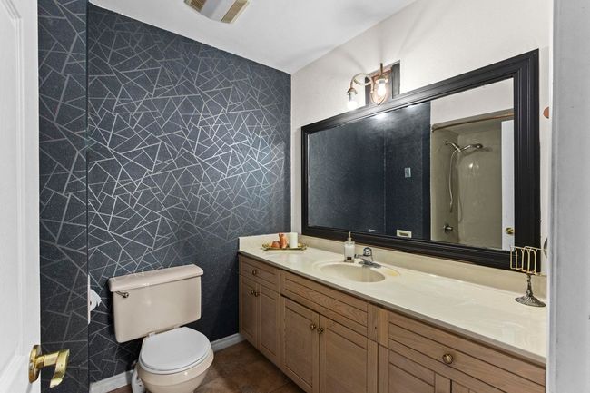 Full bath featuring tile patterned floors, vanity, a shower, toilet, and visible vents | Image 17