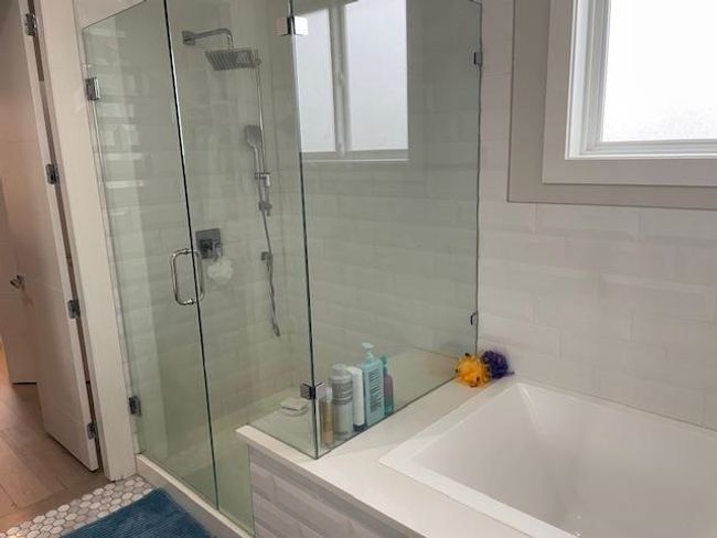 Bathroom featuring a bath and a stall shower | Image 12