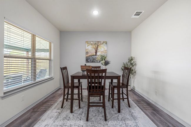 Dining space with baseboards, wood finished floors, and visible vents | Image 8