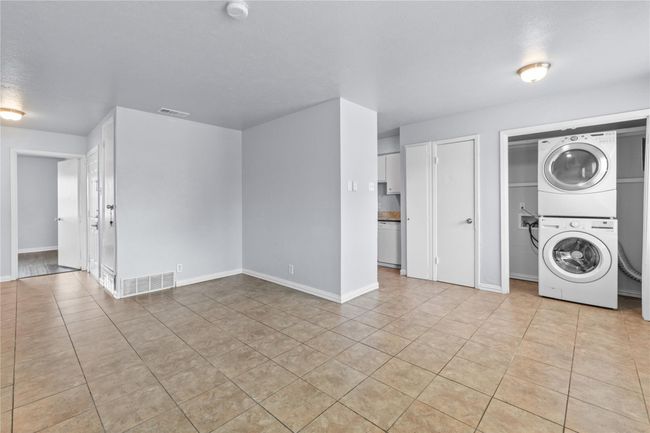 Laundry area featuring stacked washer / dryer and light tile patterned floors | Image 8