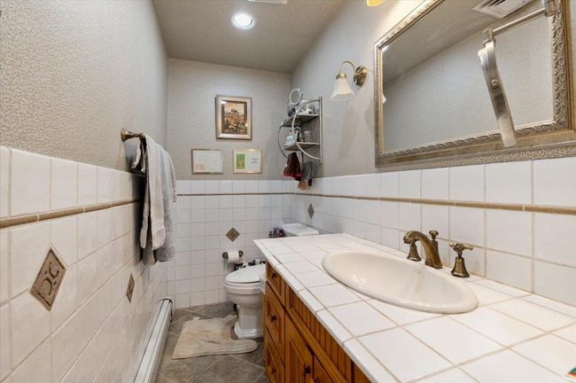 Bathroom with vanity, a textured wall, toilet, and visible vents | Image 22