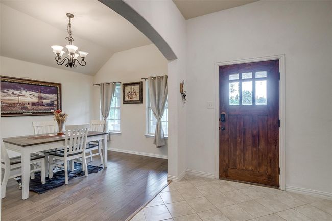 Entrance foyer featuring arched walkways, healthy amount of natural light, a chandelier, vaulted ceiling, and light wood finished floors | Image 9