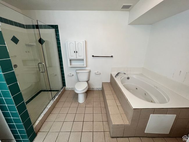 Full bathroom featuring a shower stall, a tub with jets, toilet, tile patterned floors, and baseboards | Image 5