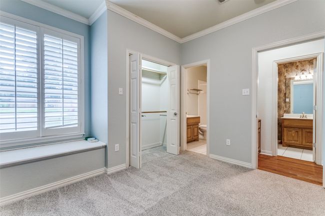 Guest Bedroom with built in Storage area/window seat, Walk in Closet and ensuite featuring new light carpet, crown molding. | Image 18