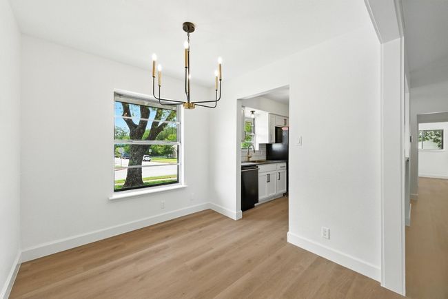 Unfurnished dining area featuring a chandelier, light wood-style flooring, and plenty of natural light | Image 8