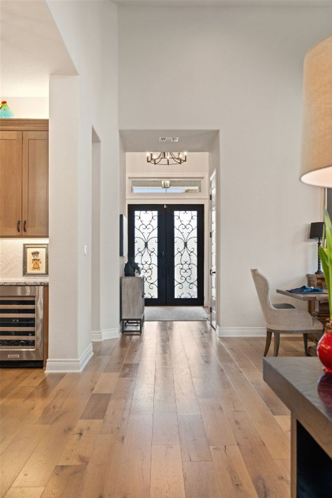 Entryway featuring beverage cooler, french doors, light wood-type flooring, and an inviting chandelier | Image 7