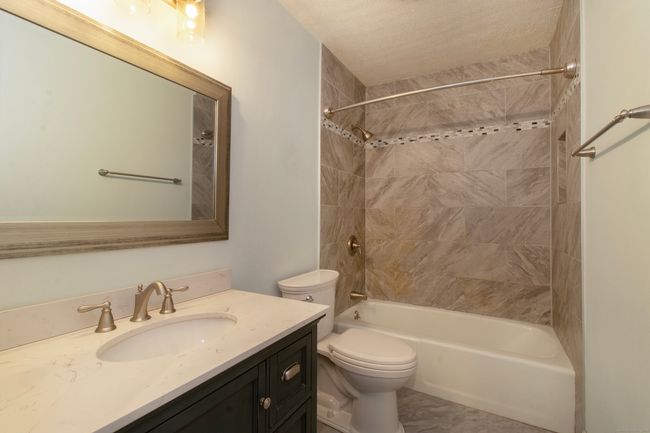 Recently updated tiled bathroom with tub/shower combo | Image 16
