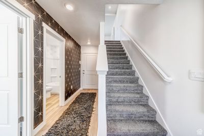 Stairway featuring tile walls and light hardwood / wood-style floors | Image 1