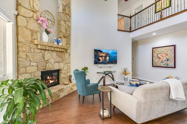 Fabulous high ceilings with a dramatic stone fireplace enhance this warm living room. | Image 7
