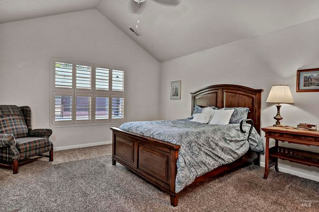 Carpeted bedroom with vaulted ceiling and a ceiling fan | Image 5