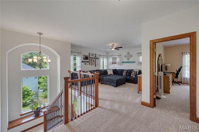 Living area with light colored carpet and a chandelier | Image 29